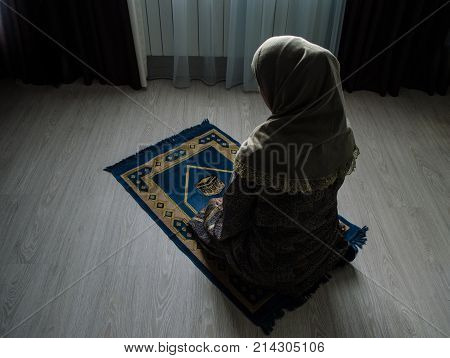 Muslim Woman Praying For Allah Muslim God At Room Near Window. Hands Of Muslim Woman On The Carpet P