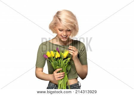 Woman smiling holding bouquet of tulip flowers studio portrait isolated on white background