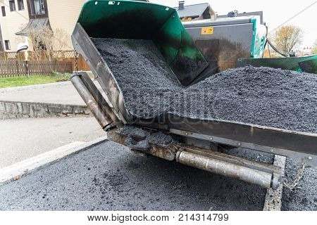 Track paver in asphalting works in action - close-up