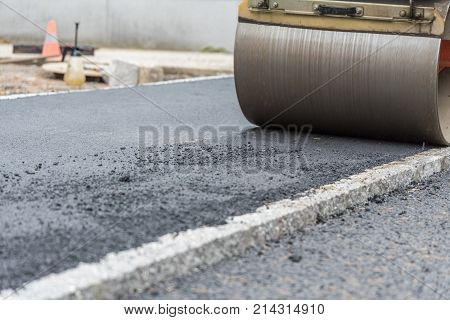 Close-up of a road roller - compacting of asphalt at the sidewalk