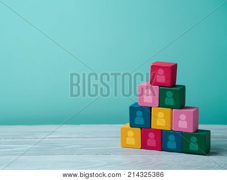 Human resourses and recruitment concept. Wooden blocks pyramid on wooden table