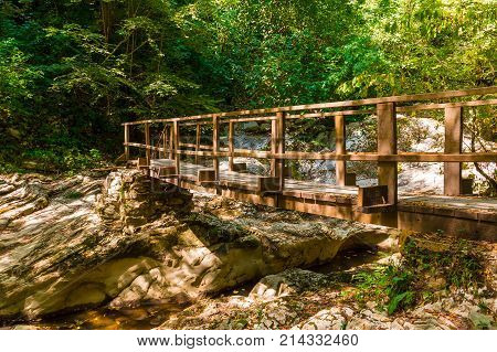 Wooden bridge over the Agura river in the Agura gorge in sunny summer day Sochi Russia