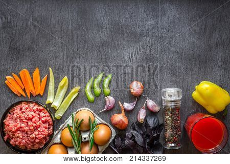 Composition of raw meat with vegetables and spice on wooden background. Top view. Copy space. Still life. Flat lay.