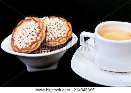Classic espresso in white cup with homemade cake on black background. Selective focus