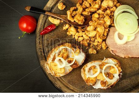 Heap of domestic salty fried pork greaves. Fatty junk food. Pork greaves on the kitchen board