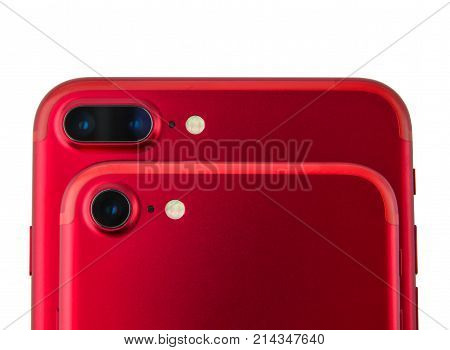 Two red phones on each other. Camera on smartphones close-up on a white background.