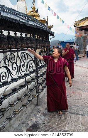 Buddhist monk spinning prayer wheels at a temple at Swayambhunath Stupa also called Monkey Temple in Kathmandu Nepal October 2, 2017