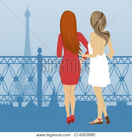 Rear view of two women standing on the embankment and look at the Eiffel Tower in Paris