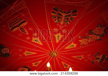 Red decorative canvas ceiling as backdrop for chandelier