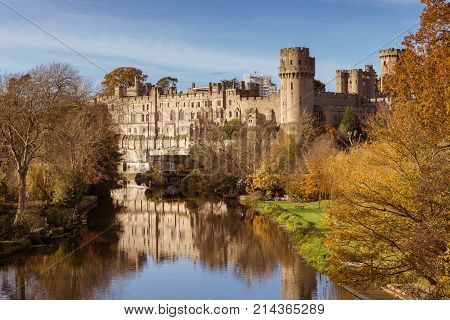 Warwick castle on the river Avon warm autumn day fall colours, Warwick, Warwickshire, England, UK, November 2017