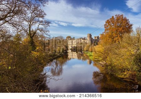 Warwick castle on the river Avon warm autumn day fall colours, Warwick, Warwickshire, England, UK, November 2017