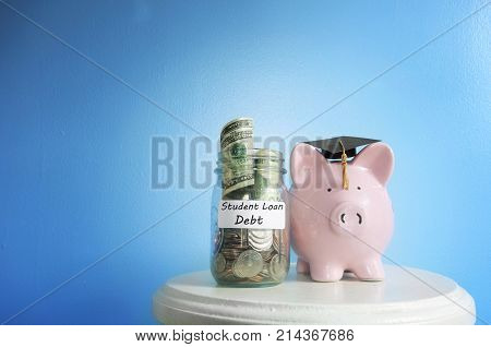 Piggy bank with graduation cap beside a student loan coin jar