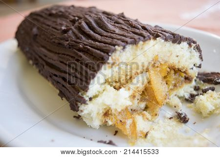 chocolate yule log cake with stuffing of cream and candied