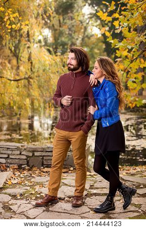 Cute couple in park filled with autumn colors.