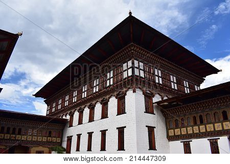 White stone and wooden Dzong temple in Bhutan against blue sky