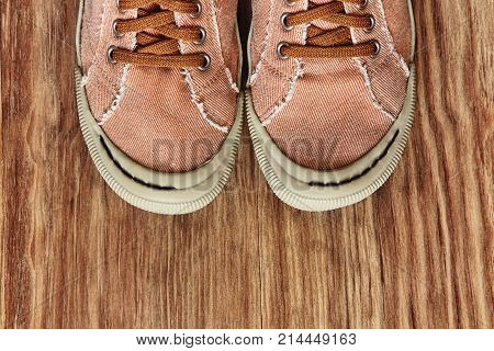 Front part of Gym shoes on grunge wooden background.Top view and toned image.