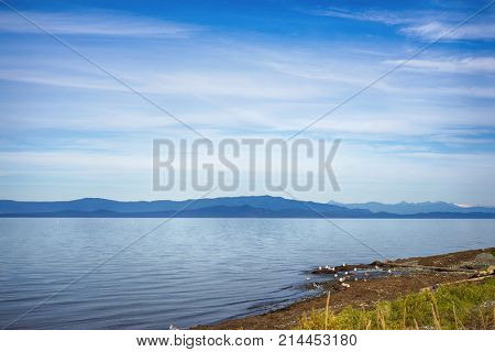 Seaside view of Qualicum beach in Vancouver Island, with the Canadian Rockies in the background, British Columbia, Canada