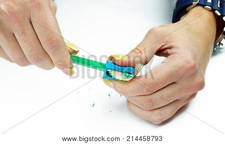 Hands with sharpener and pencil on an isolated background