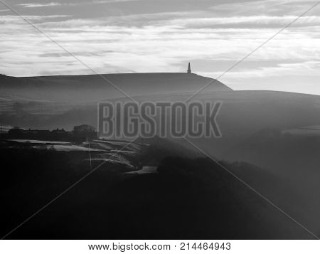stoodley pike in west yorkshire with morning mist in winter monochrome image