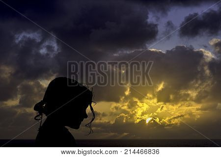 Silhouette of a young girl with sunrise over the ocean in background - Los Cocoteros, Lanzarote, Canary Islands, Spain