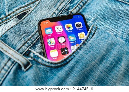 PARIS FRANCE - NOV 10 2017: New Apple iPhone X smartphone telephone mobile in pocket of fashion denim jeans pants trousers with home screen apps