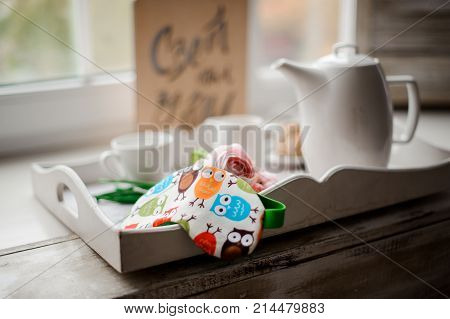 Cute sleeping mask with pretty owls print arranged on the white trey against the window