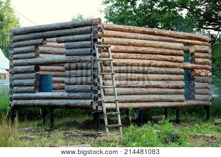 Assembling a wooden frame and building a house. Russia. Texture of old wooden logs and holes for the future door and windows