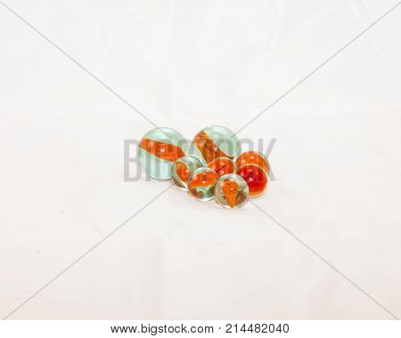 two sizes of orange cats-eye marbles at rest