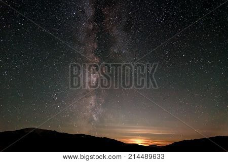 Beautiful panorama of the night starry sky with the Milky Way galaxy above the mountains stars and moonset