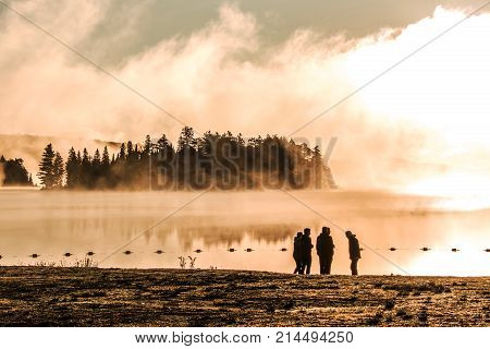 people standing at Lake of two rivers algonquin national park ontario canada sunset sunrise with fog foggy mystical atmosphere background
