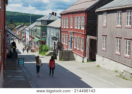 ROROS, NORWAY - JUNE 24, 2013: Unidentified tourists walk by the street in Roros, Norway. Town of Roros is declared a UNESCO World Heritage site.