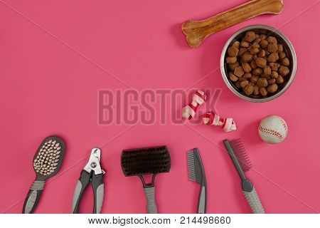 Accessories for the grooming of the dog on pink background. Combs and brushes for dogs. Top view. Still life. Copy space. Flat lay