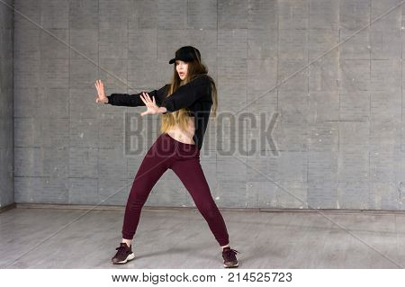 Pretty girl dancing modern dance. Beautiful slim young woman performing contemporary dance on studio background. Skillfull and talented youth.