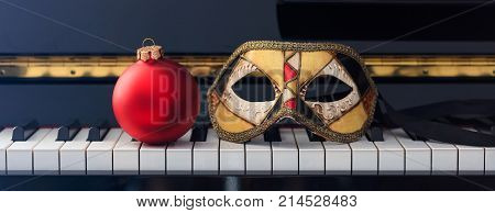 Red Chritmas Ball And Carnival Mask On Piano Keyboard, Front View