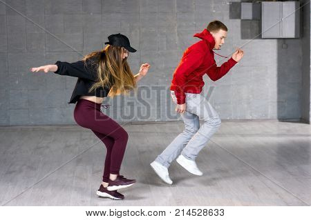 Couple is dancing contemporary dance. Young boy and girl performing modern dance on studio background.