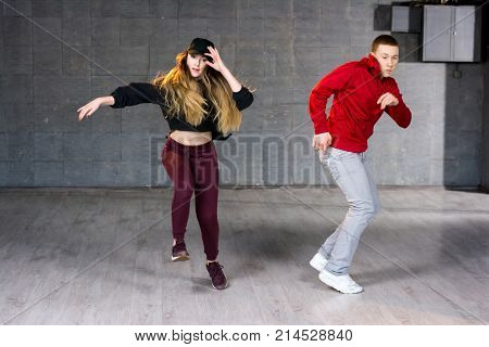 Hip-hop dancers in movement. Modern style dancers dancing contemporary dance on studio background. School of modern dance.