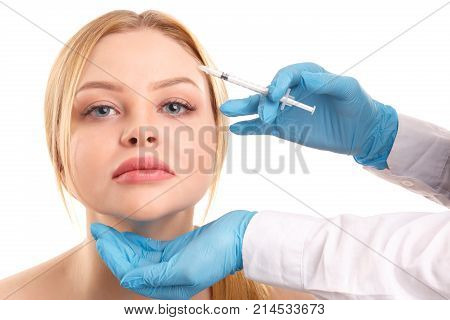 The face of a young and beautiful woman who is injected into the forehead. Isolated on white background.