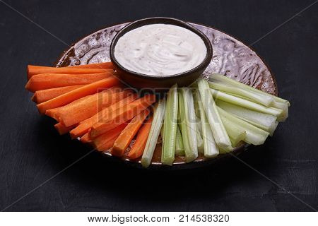 crudites. carrot and celery on a plate with dip