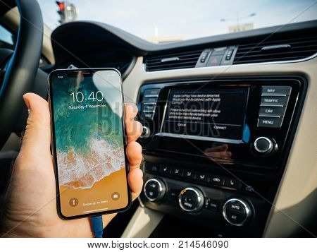 FRANKFURT GERMANY - NOV 4 2017: Man connecting his new iPhone X 10 to the navigation system of the car with CarPlay - message on GPS - new device detected