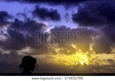 Silhouette of a young girl with sunrise over the ocean in background - Los Cocoteros, Lanzarote, Canary Islands, Spain