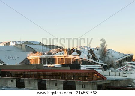 ATLANTA, GA - NOVEMBER 2017: The massive structure of the Georgia Dome collapses as it's imploded in the shadow of the new Mercedes-Benz Stadium in Atlanta GA on November 20 2017.