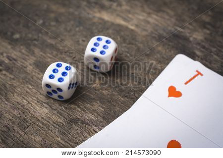 two game dice number double six and ace of hearts on the wooden table