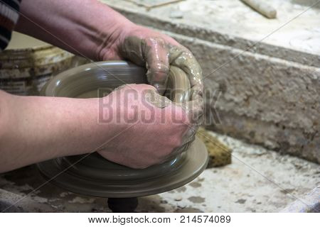 Man potter at work creating some traditional cups of white clay, Psychro, Lassithi, Crete, Greece.