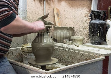 Man potter at work creating some traditional cups of white clay, Psychro, Lassithi, Crete, Greece.