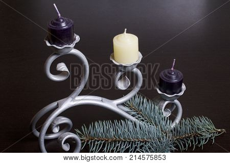 The Branches Of The Blue Spruce Lie On The Plane. Among Them, Candles Are White And Black On A Forge