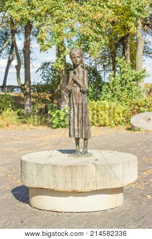 Kiev Ukraine October 08 2015: Sculpture of young girl with wheat ears in their hands known as the "Bitter Memory of Childhood" on alley of National Museum "Memorial to Holodomor victims"