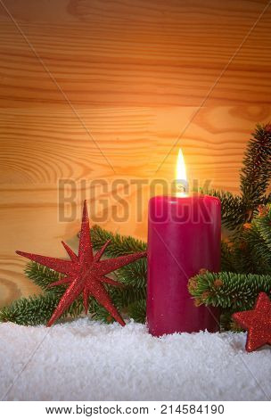Avent candle and christmas decoration isolated on wood background. Christmas background with snow, candle and red stars.
