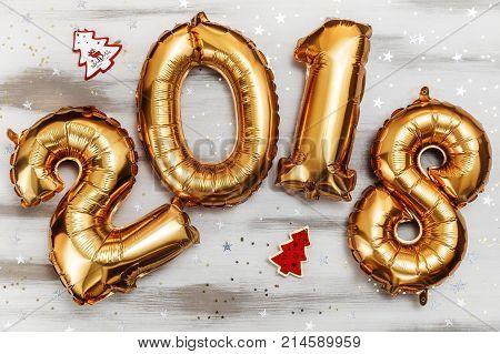 Bright gold balloons figures 2018, New Year Balloons with glitter stars on white wood table background. Christmas and new year celebration