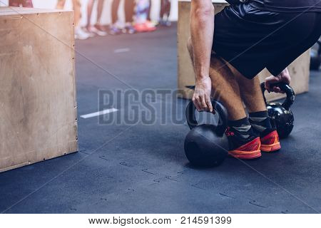Man Pulling Kettlebells Weights In The Functional Fitness Gym
