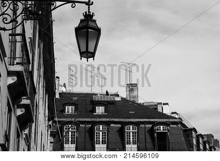 Photo of a gothic style street lamp on the roofs of Lisbon